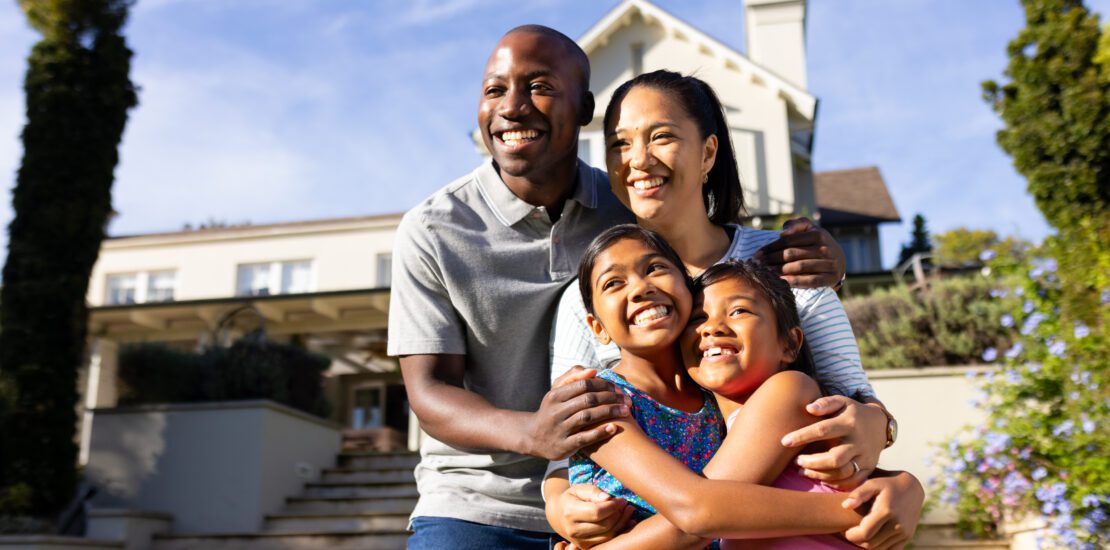 Smiling family in front of their new home after completing a home title search
